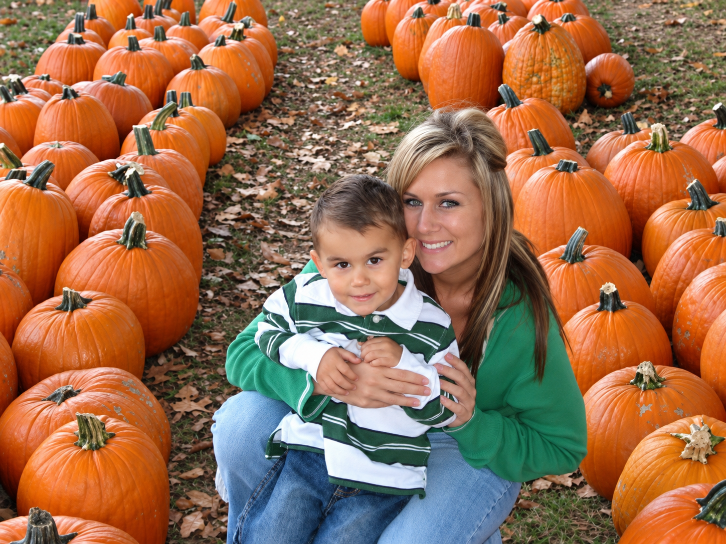 Krysten holding her young son in a pumpkin patch